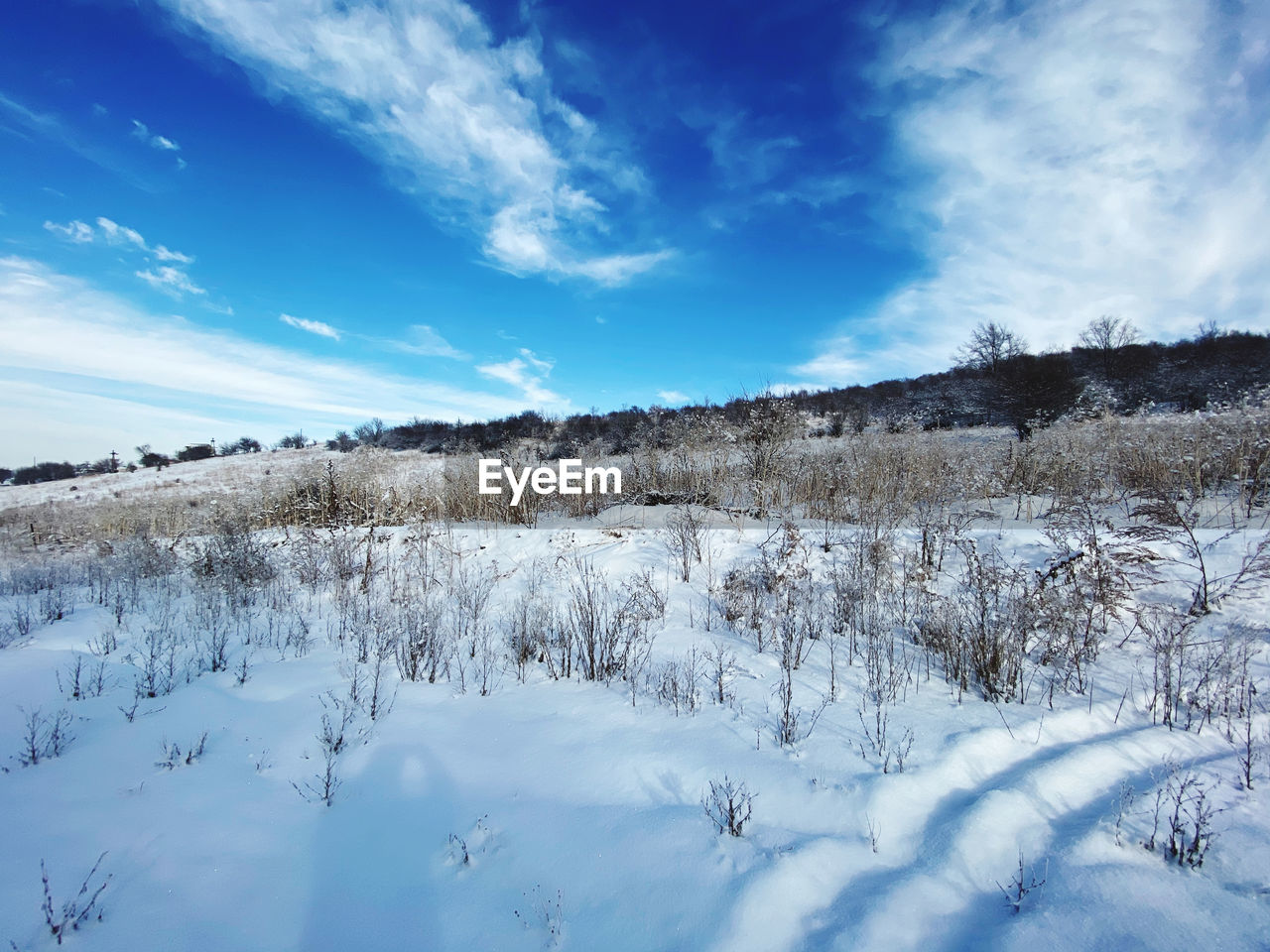 Scenic view of snow covered field against sky