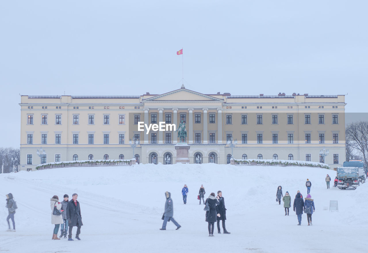 People outside royal palace against sky during winter