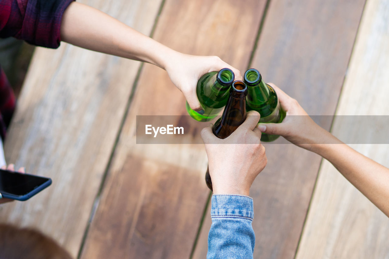 Cropped shot of people holding beer glasses celebrating in the summer vacation