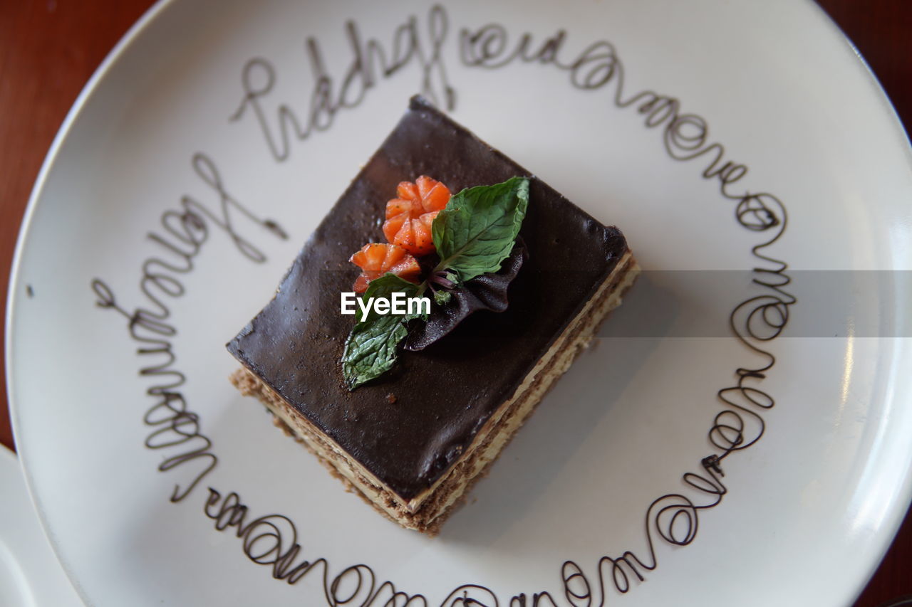 HIGH ANGLE VIEW OF CAKE SLICE IN PLATE WITH TEXT