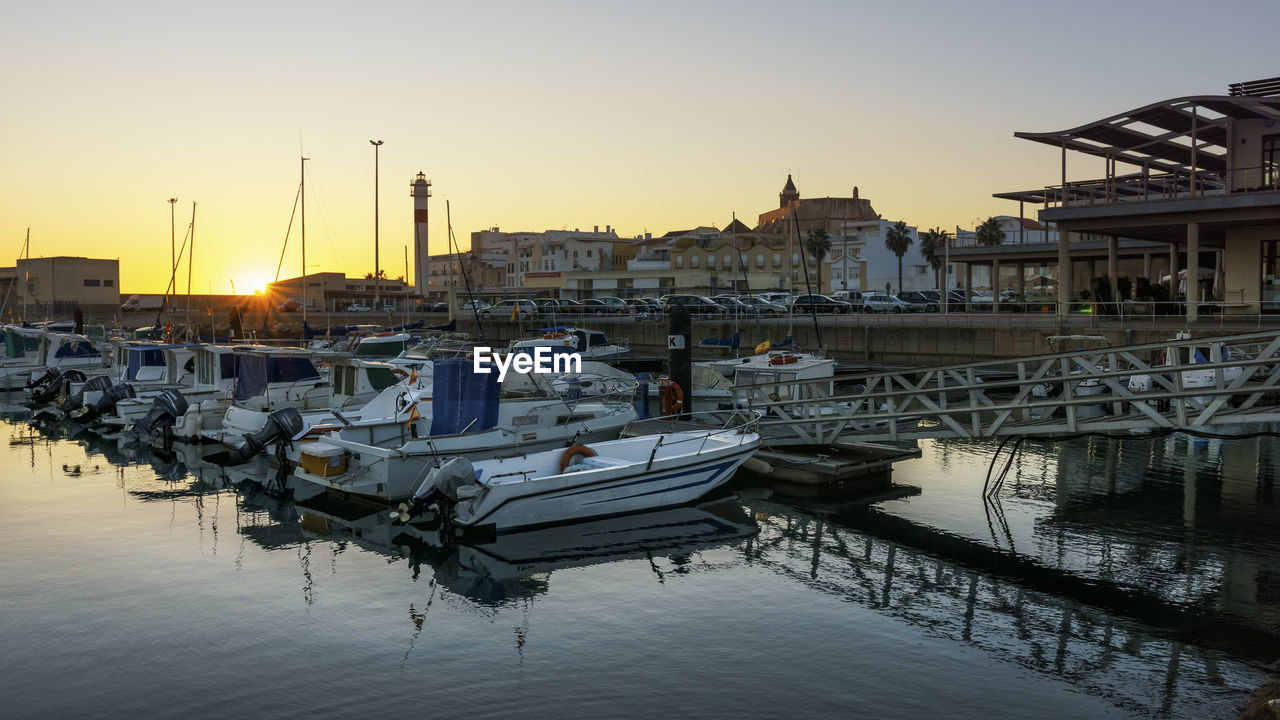 BOATS MOORED AT HARBOR AGAINST SKY