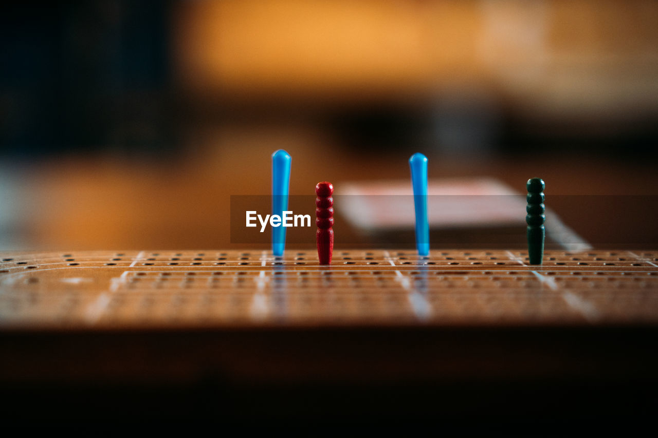 Multicoloured pegs on crib board, eye level.