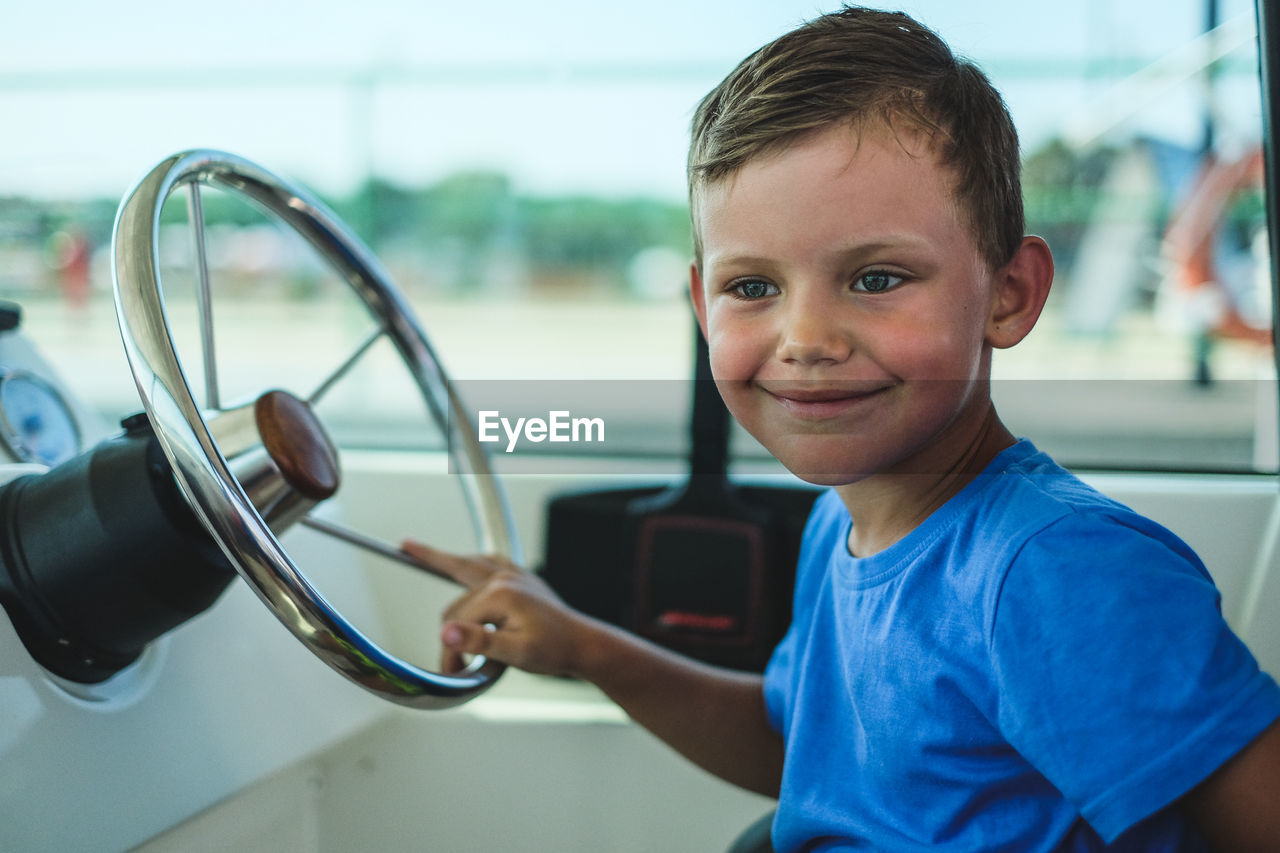 Smiling boy sitting in car