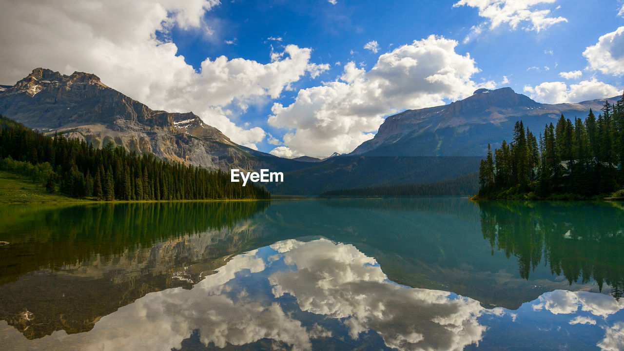 Scenic view of lake and mountains against cloudy sky