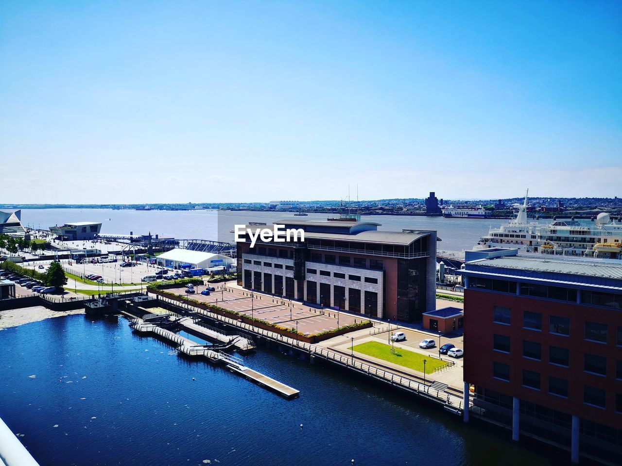 High angle view of buildings by sea against clear sky