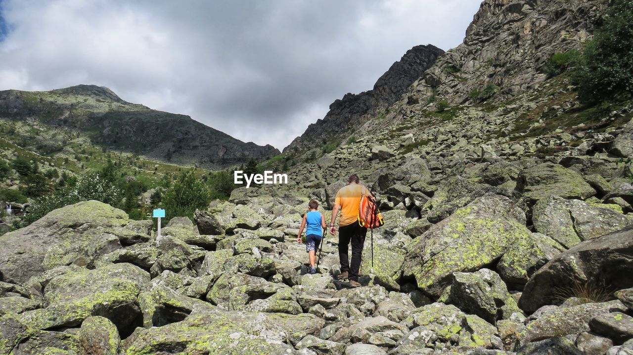 Rear view of father and son hiking on mountain