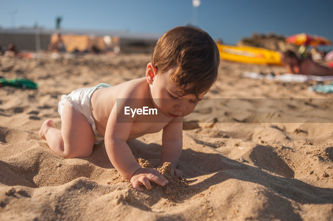 BOY PLAYING WITH SAND