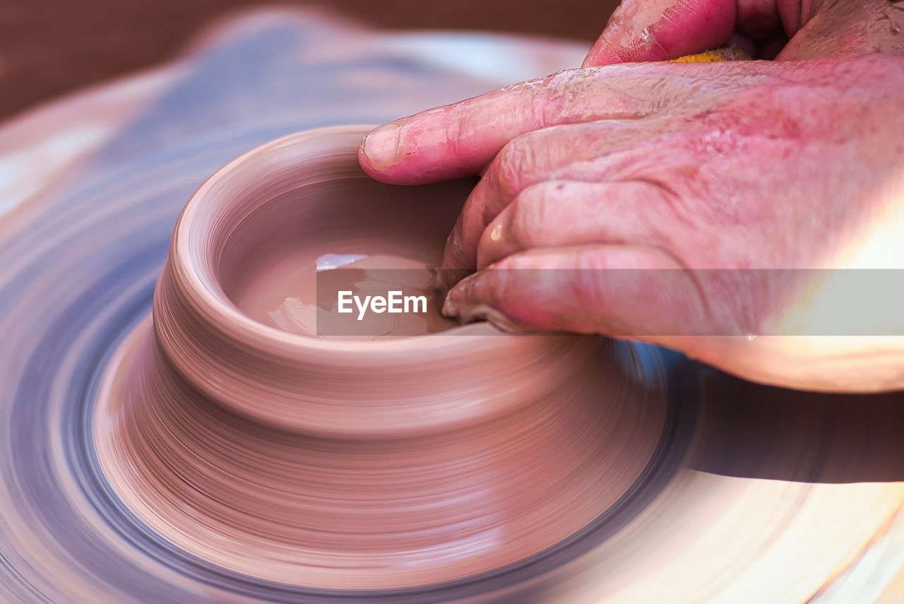 cropped hand of person making pottery