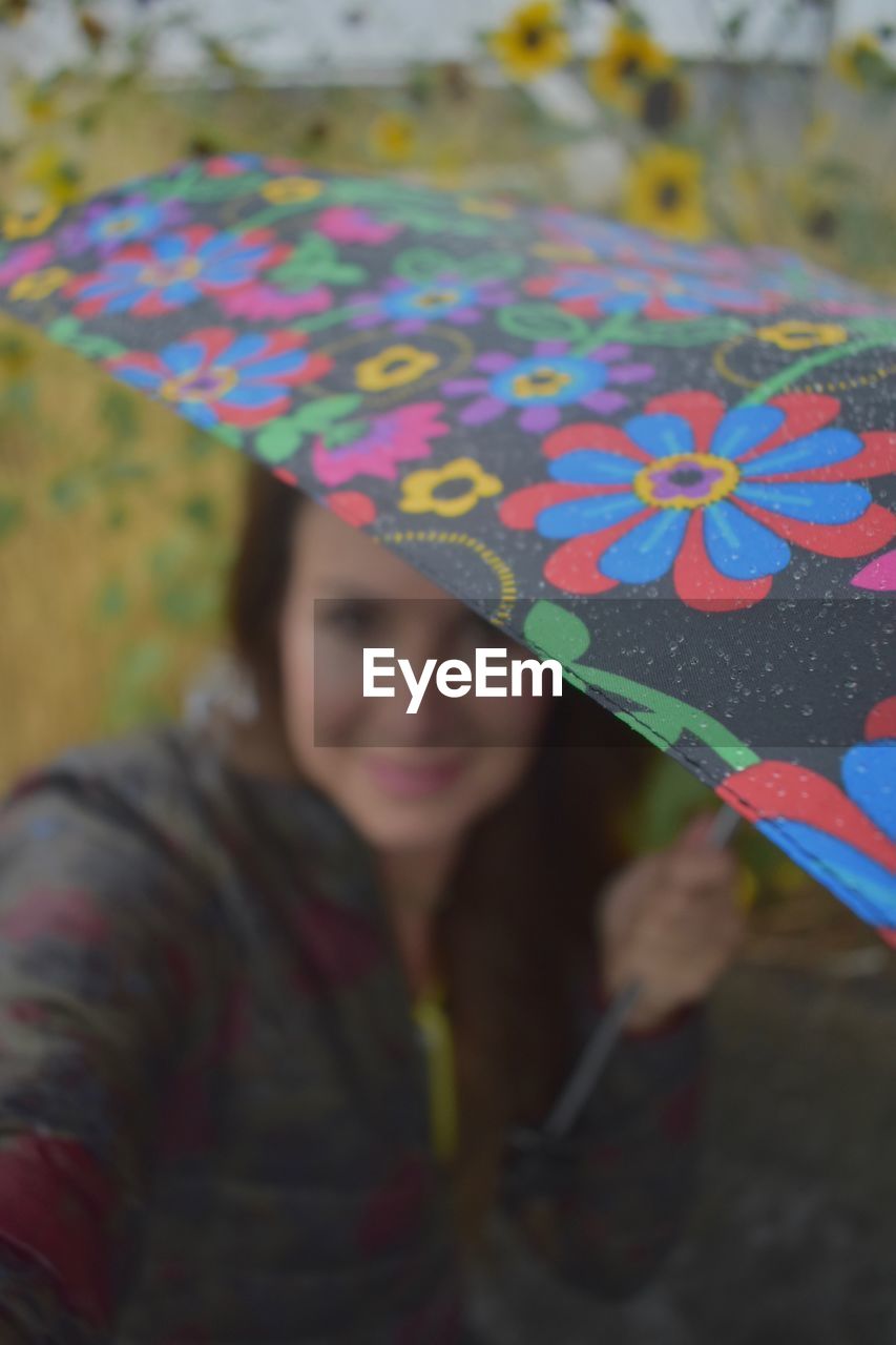 Close-up of woman with umbrella during rainy season