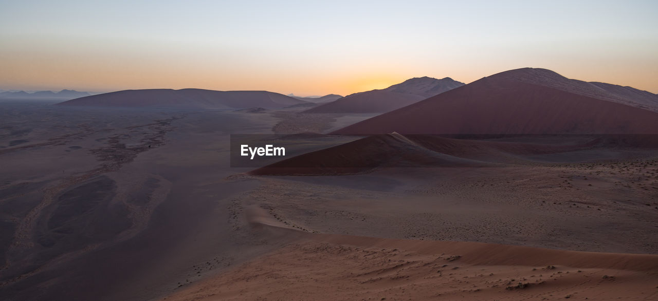 Scenic view of desert against sky during sunset