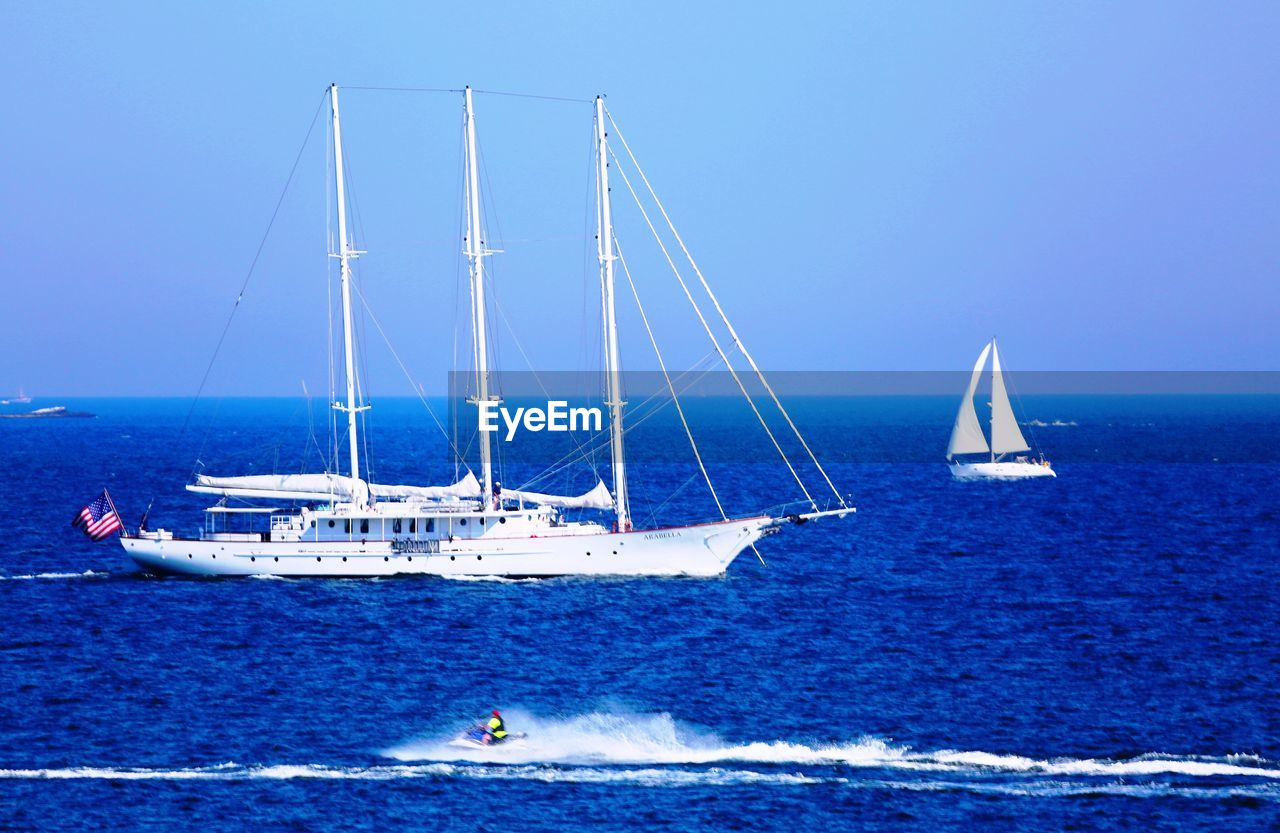 SAILBOATS IN SEA AGAINST CLEAR BLUE SKY