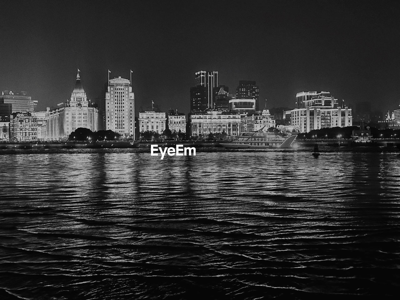 buildings by river against clear sky