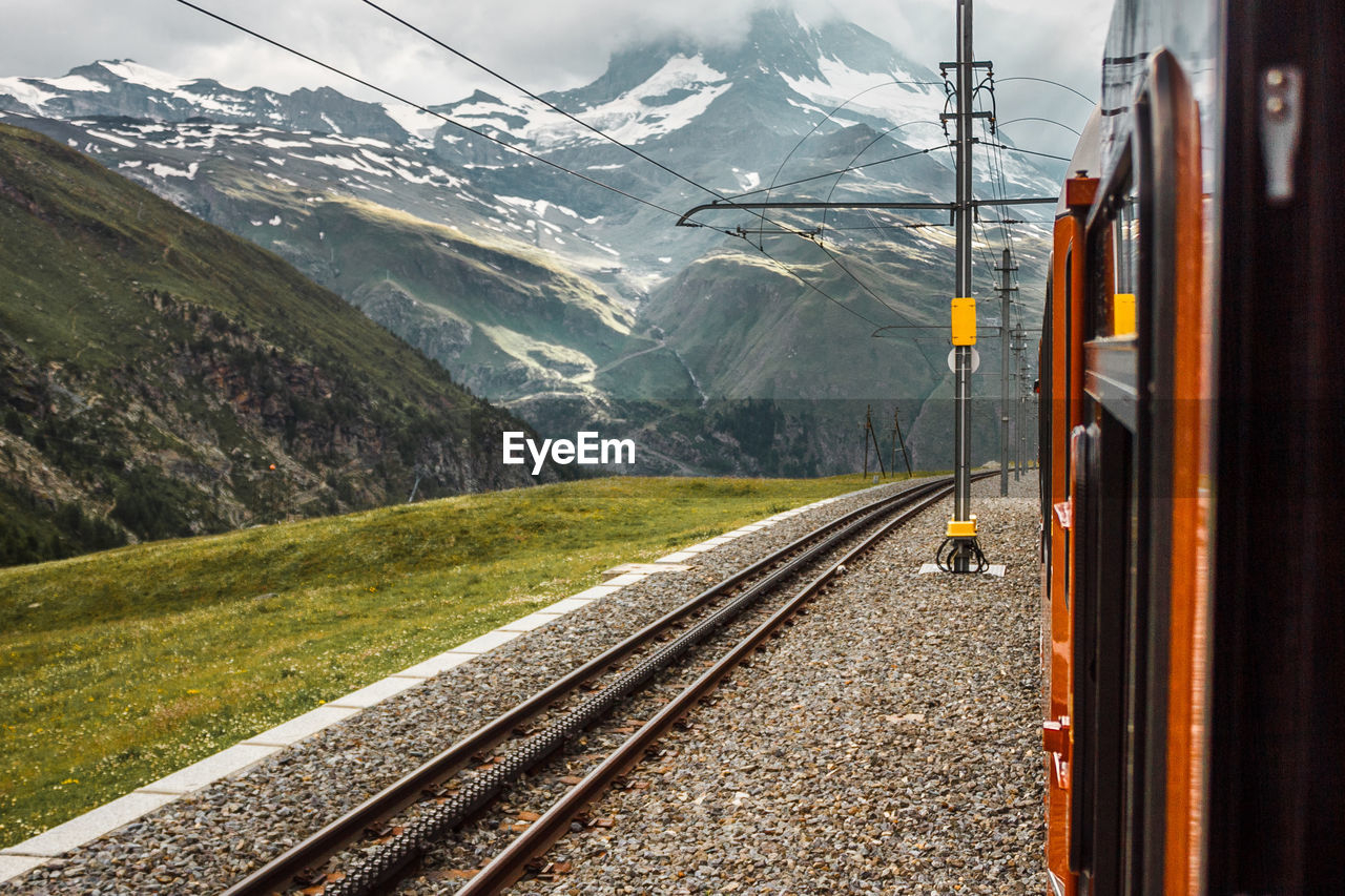 Railway and red train close up, gornergrat mountains. zermatt, swiss alps. adventure in switzerland.