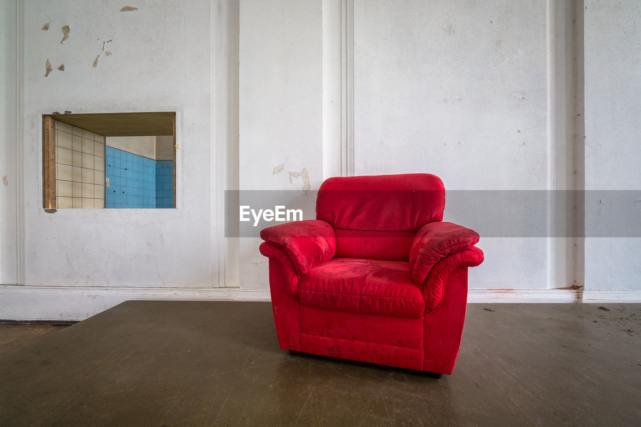 Empty red couch against wall