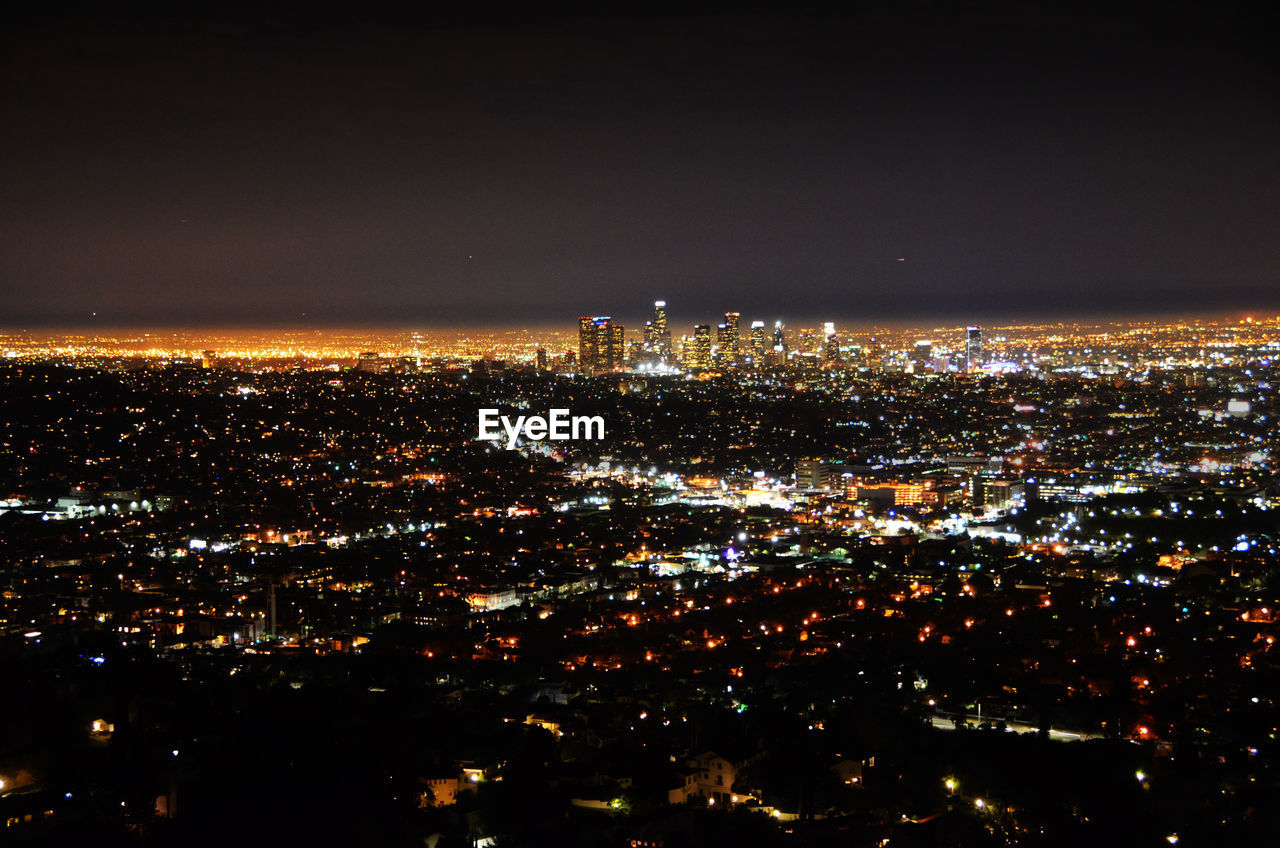 Aerial view of illuminated cityscape against sky at night