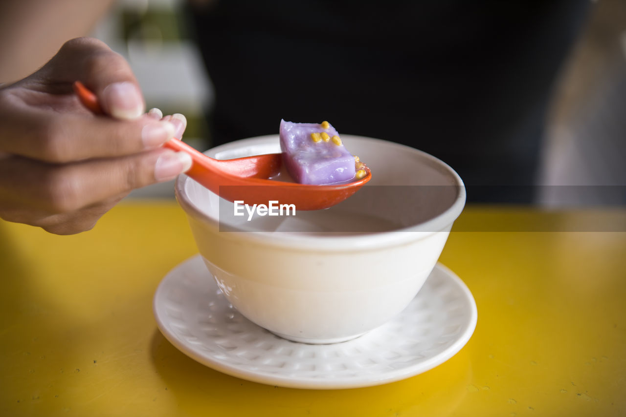 Close-up of woman holding food in spoon