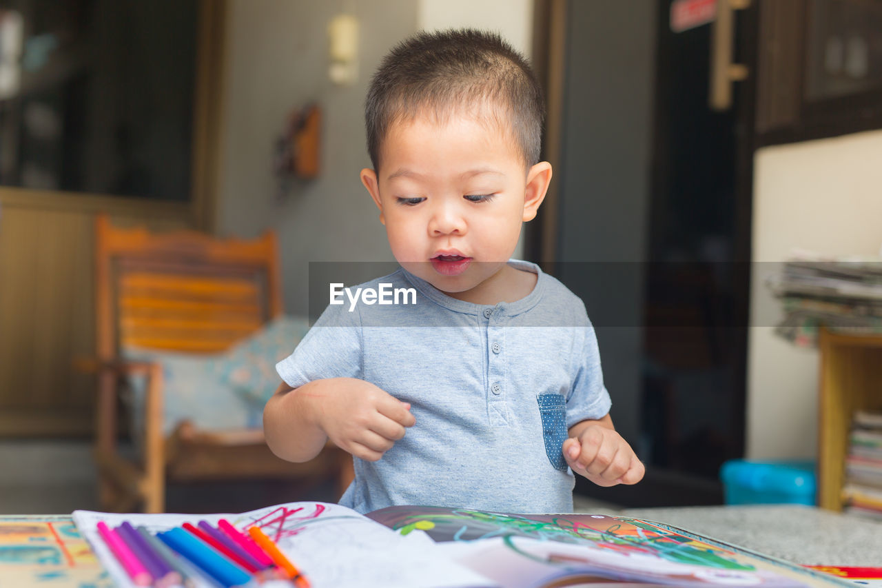 Boy drawing on table at home