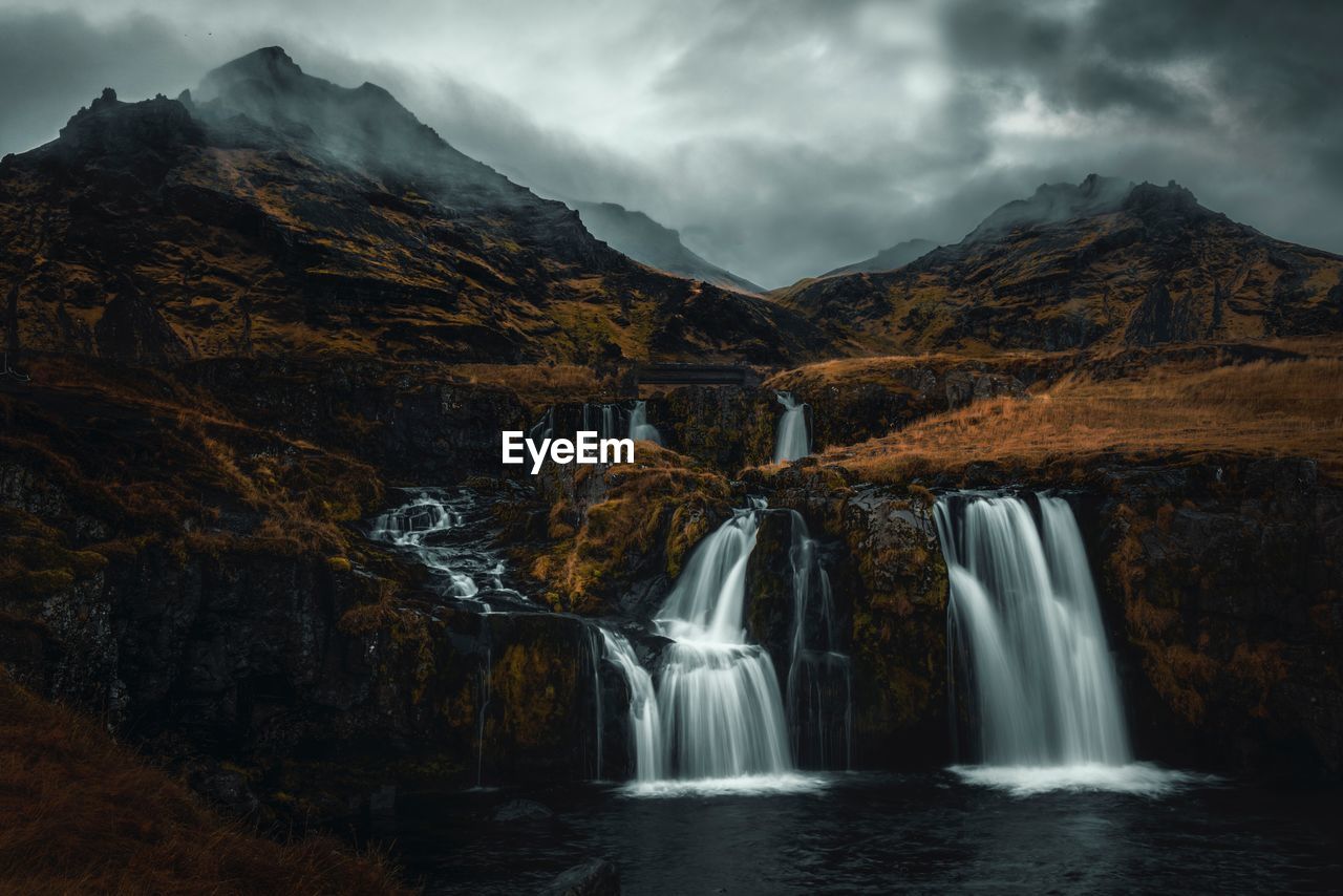 Scenic view of waterfall against sky