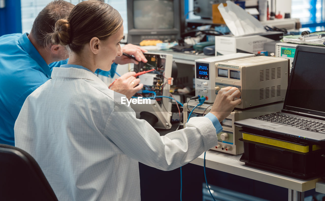 Technicians repairing equipment at workplace