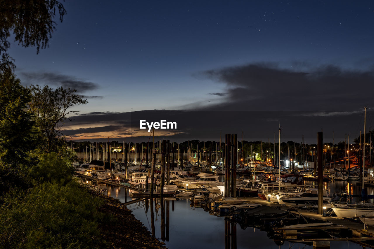 SAILBOATS MOORED AT HARBOR