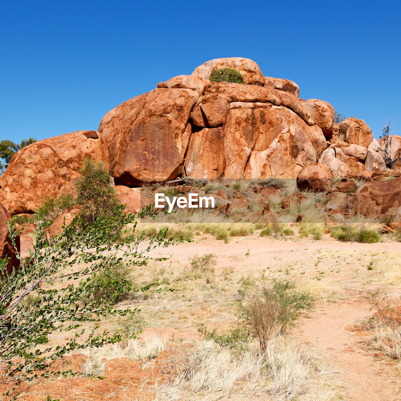 Rock formations on landscape against clear blue sky