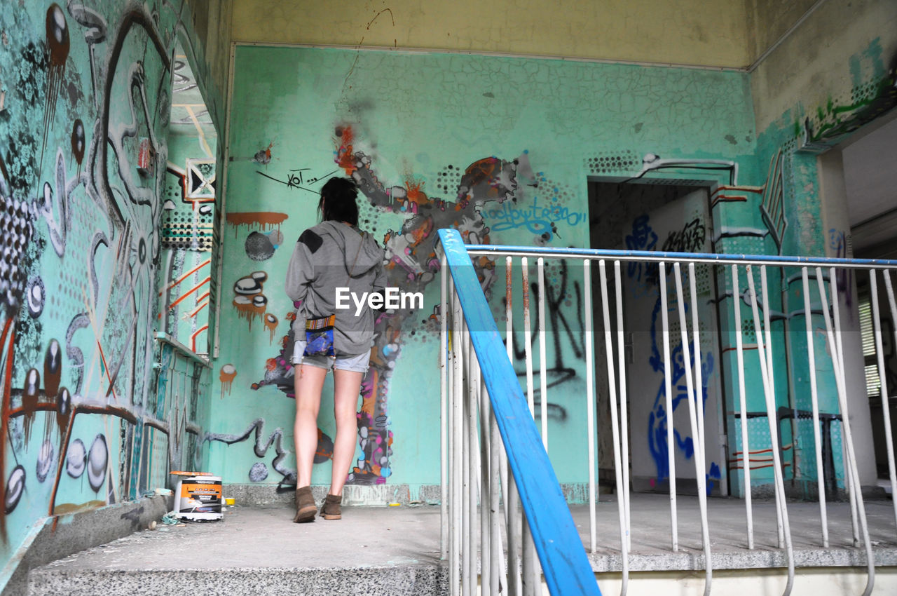 MAN IN SHOPPING CART IN CORRIDOR