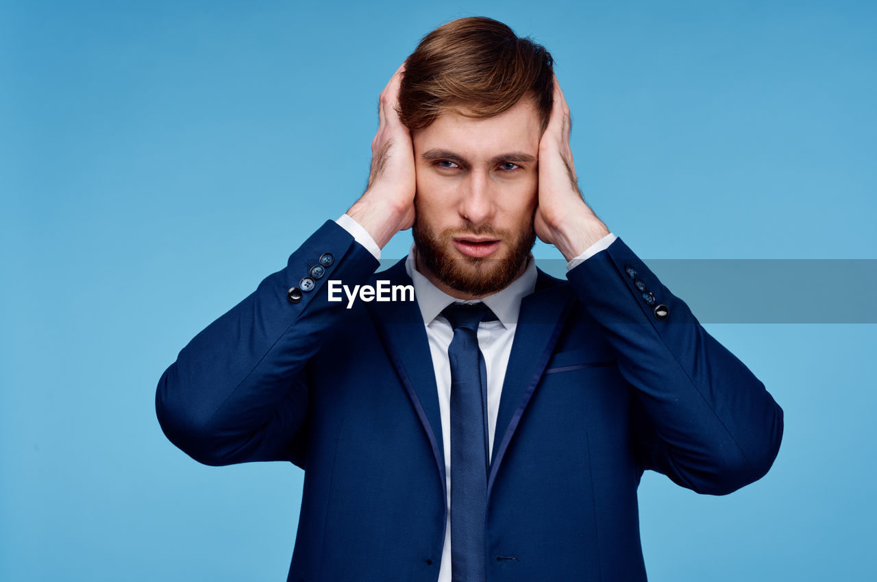 Portrait of young man against blue background