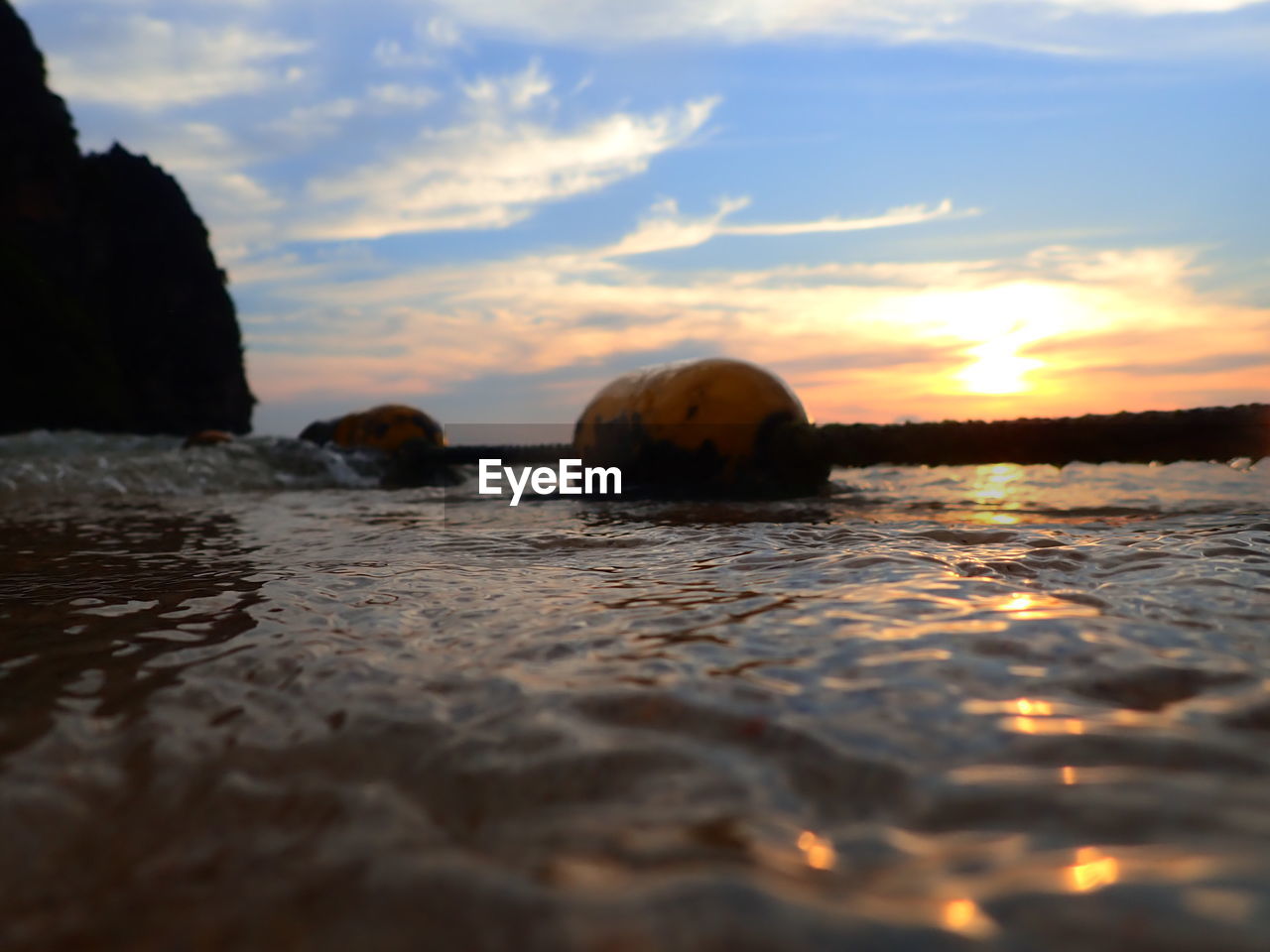 Surface level of sea against sky during sunset