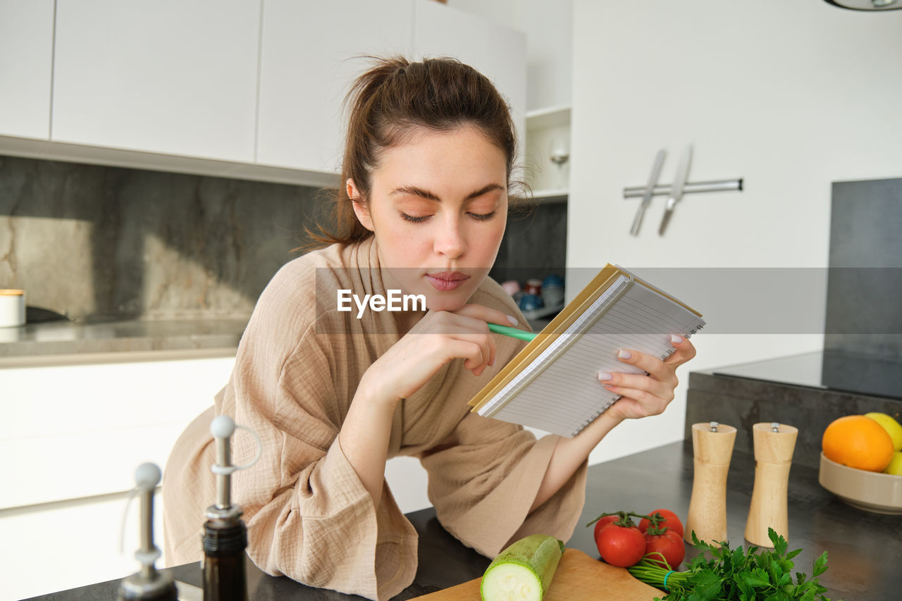 portrait of cute girl using mobile phone while sitting on table