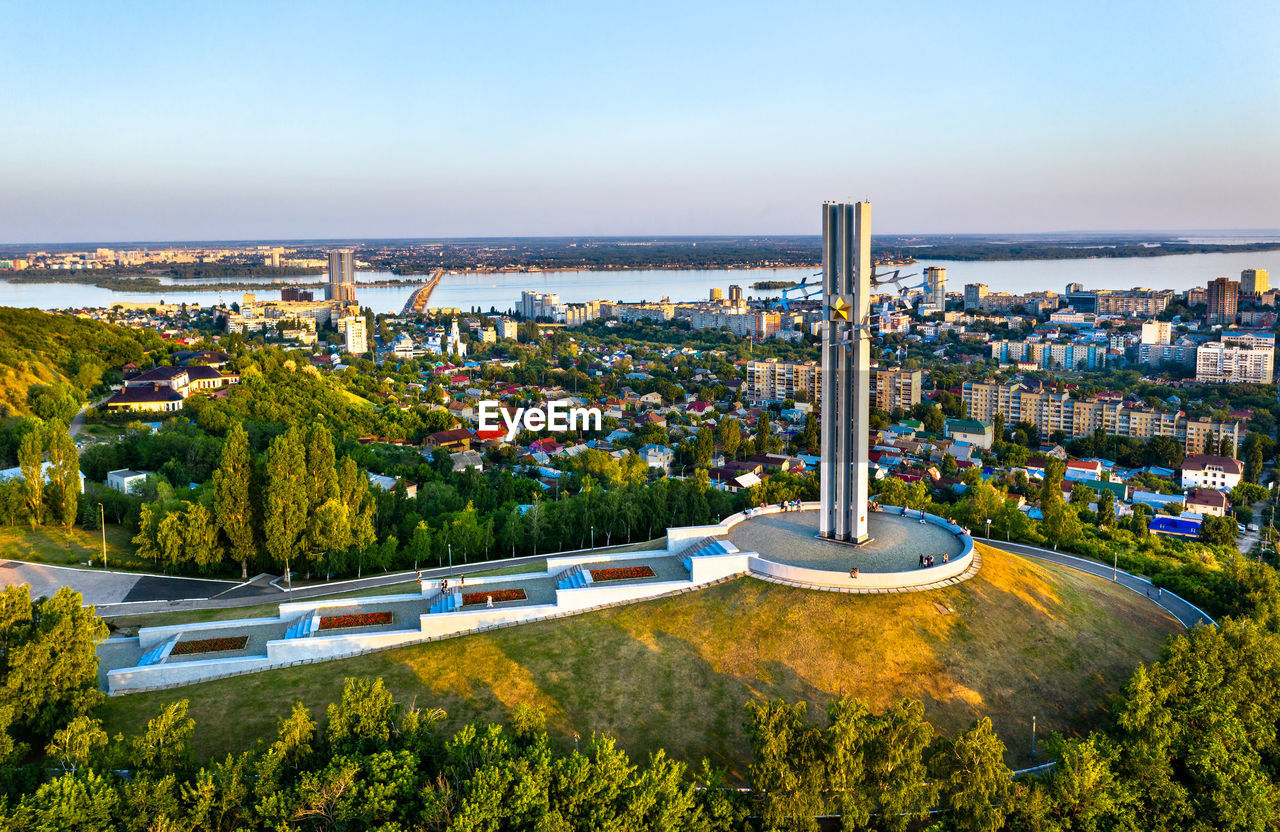 HIGH ANGLE VIEW OF TREES BY BUILDINGS AGAINST SKY