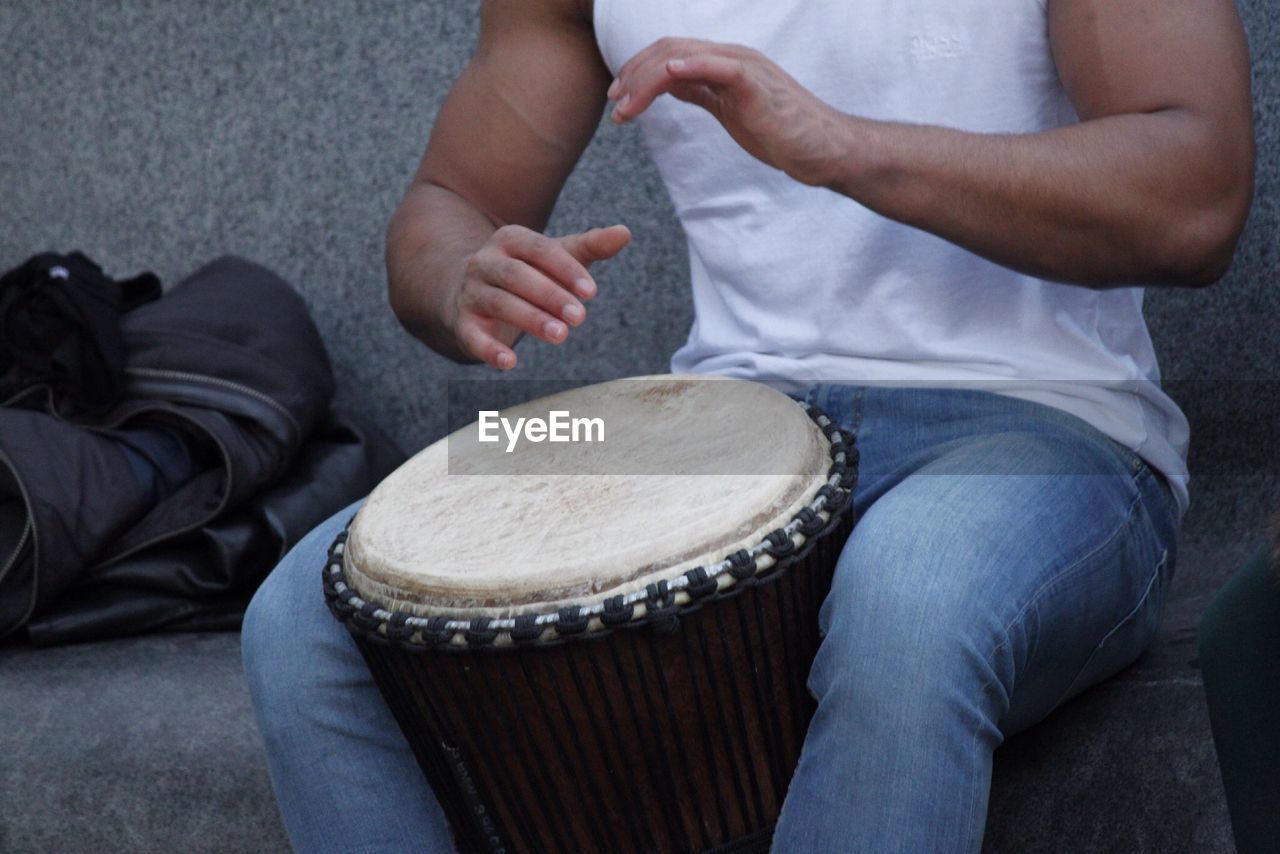 Midsection of man playing bongo outdoors
