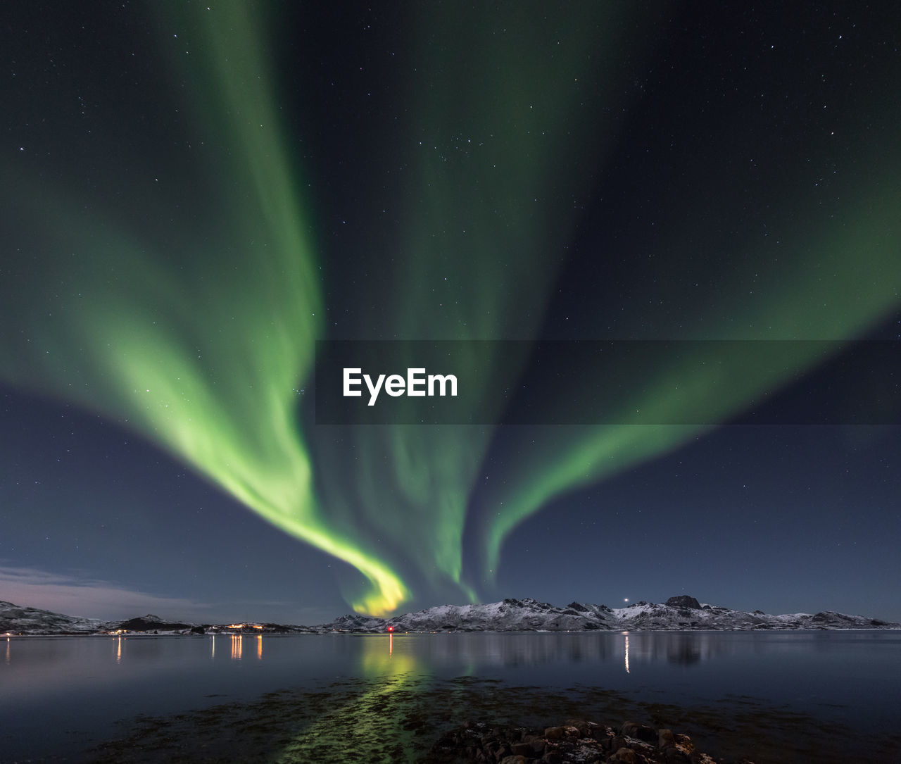 Low angle view of aurora borealis over sea at night during winter