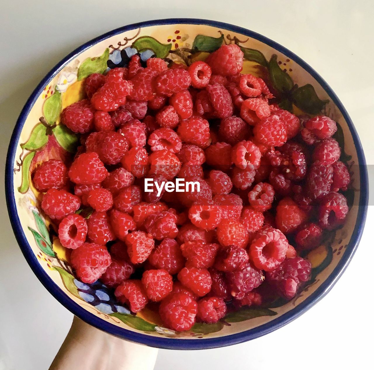 HIGH ANGLE VIEW OF RASPBERRIES IN BOWL