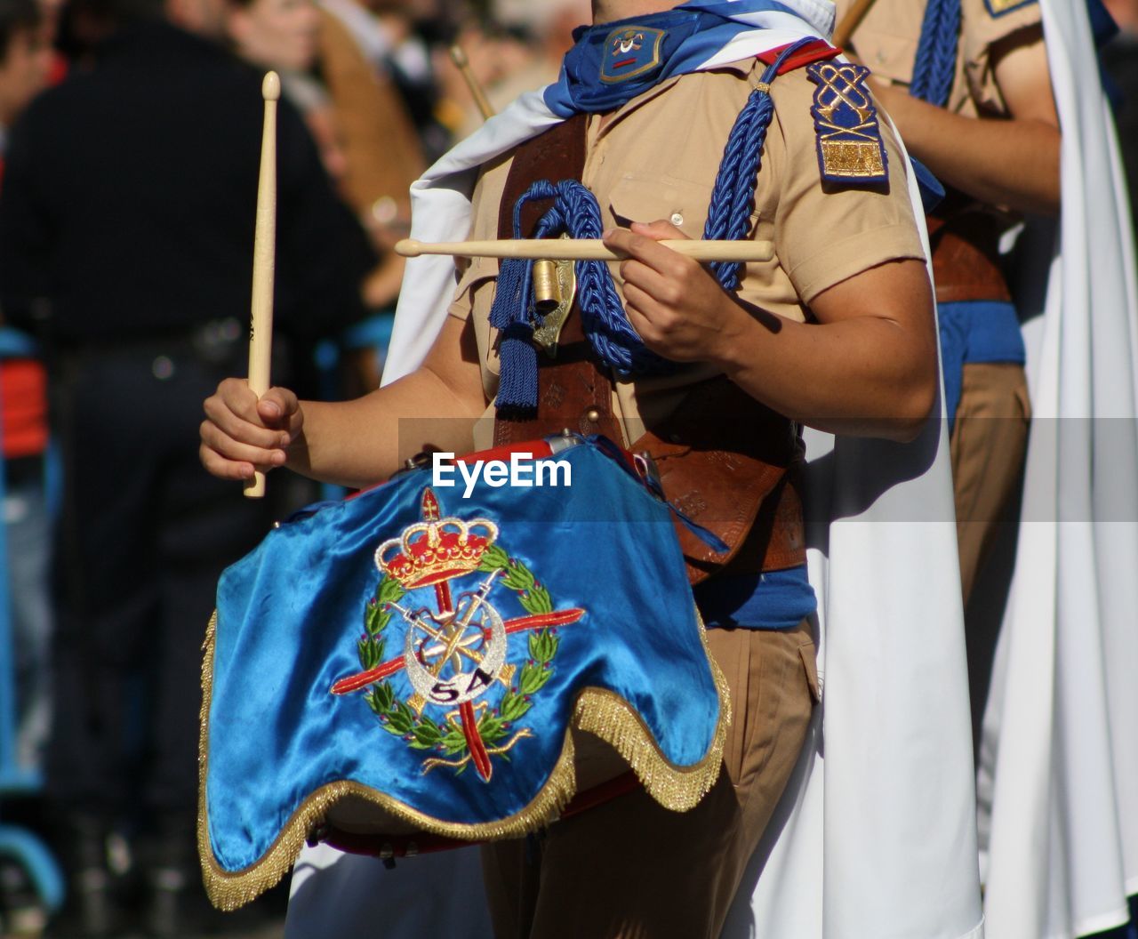 Midsection of woman playing drum while marching 