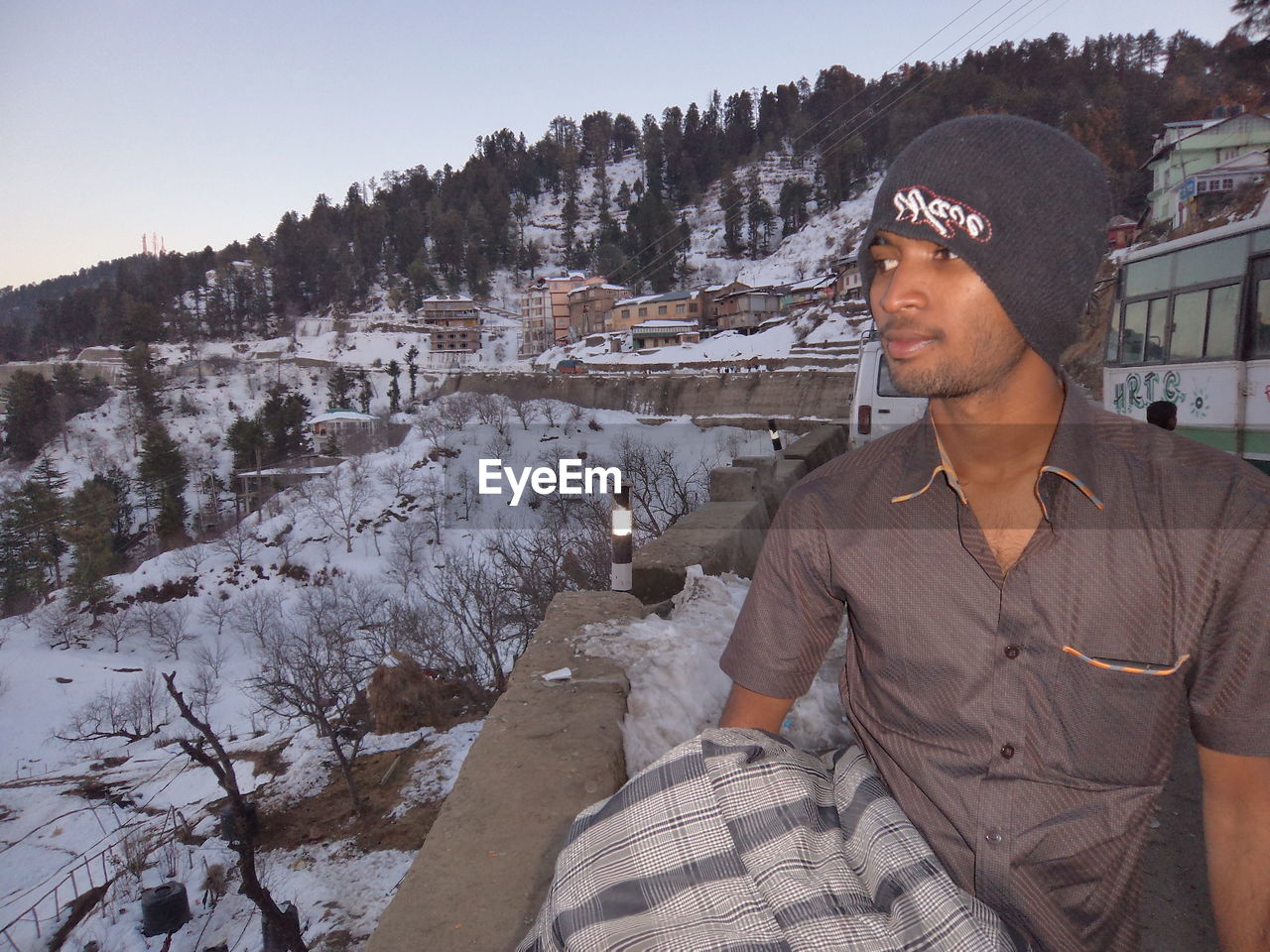 Smiling man on road against snow covered mountain