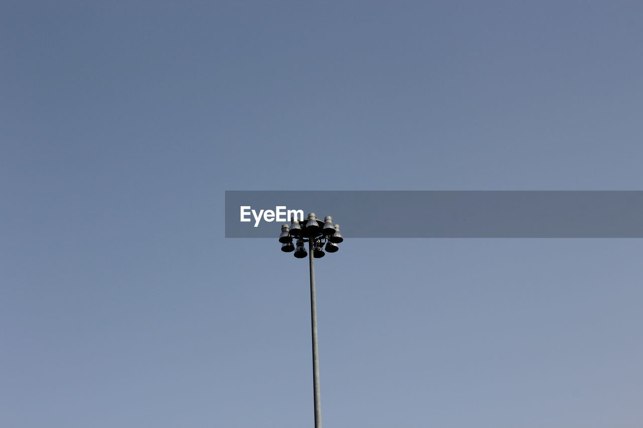 Low angle view of floodlight against clear blue sky