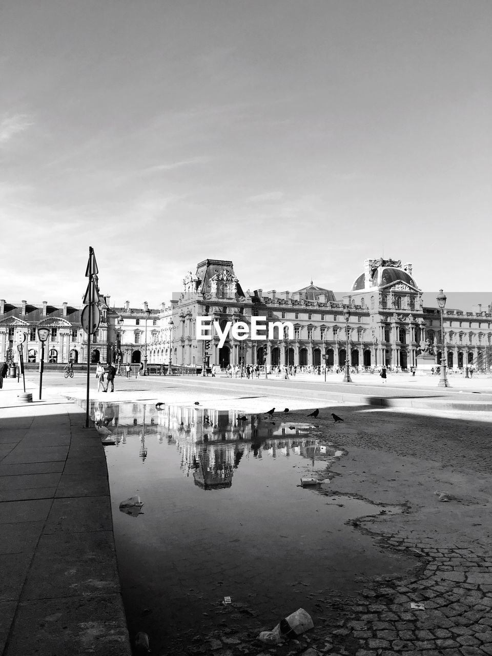 The louvre reflecting in puddle on street