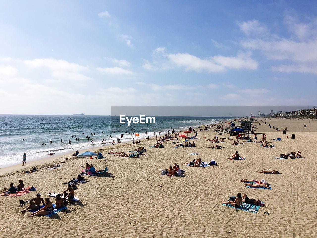 People enjoying at manhattan beach against sky