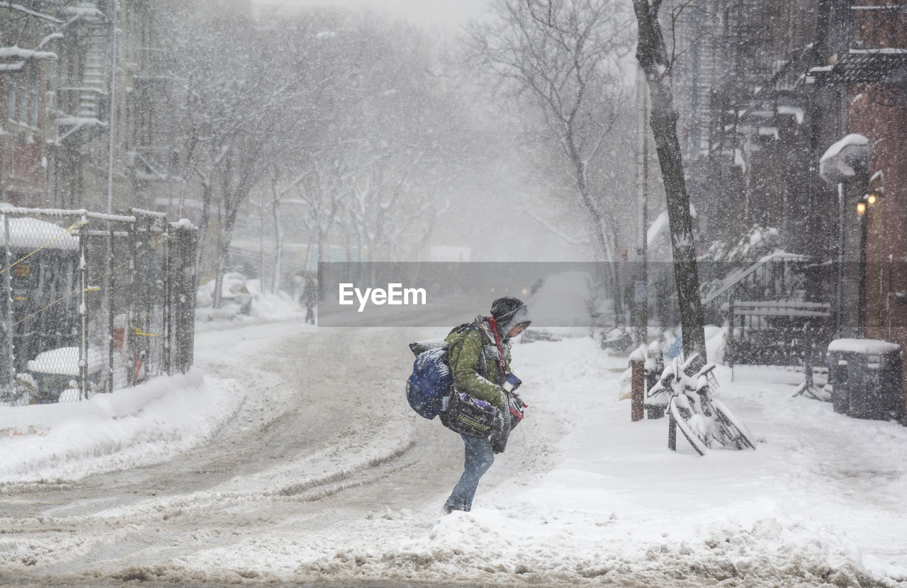 Rear view of person on snow covered street