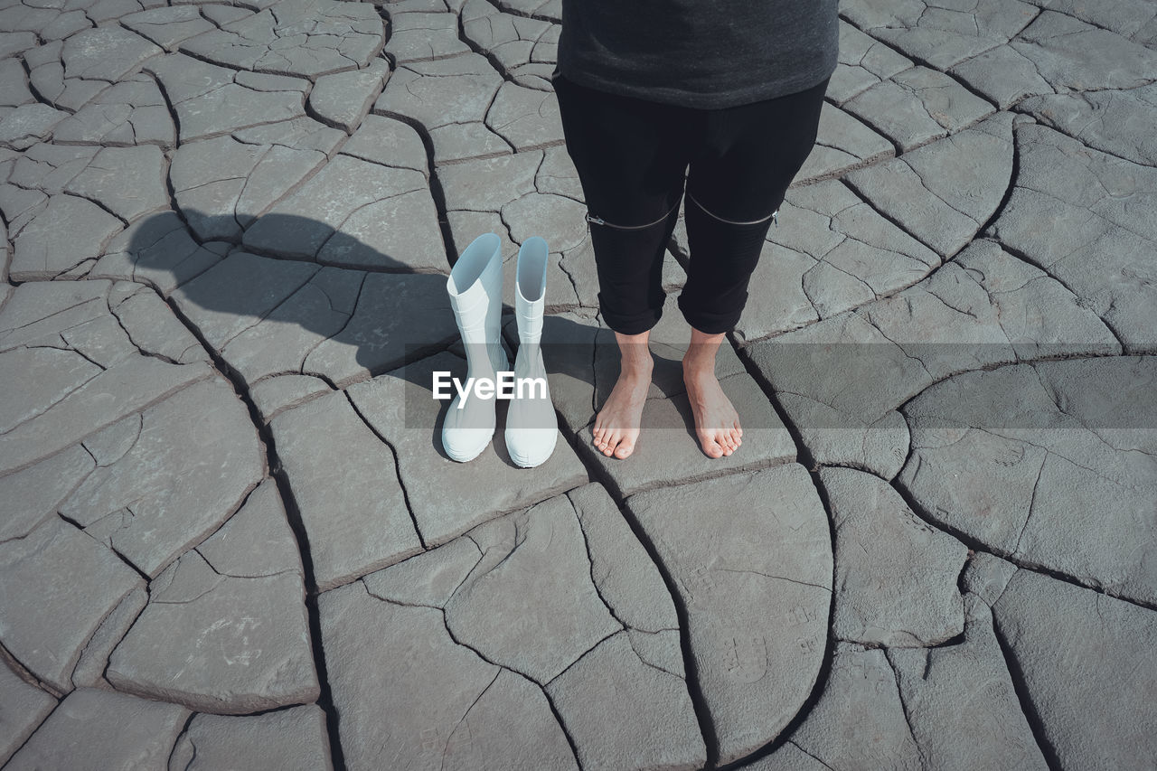 Low section of woman standing on cracked ground