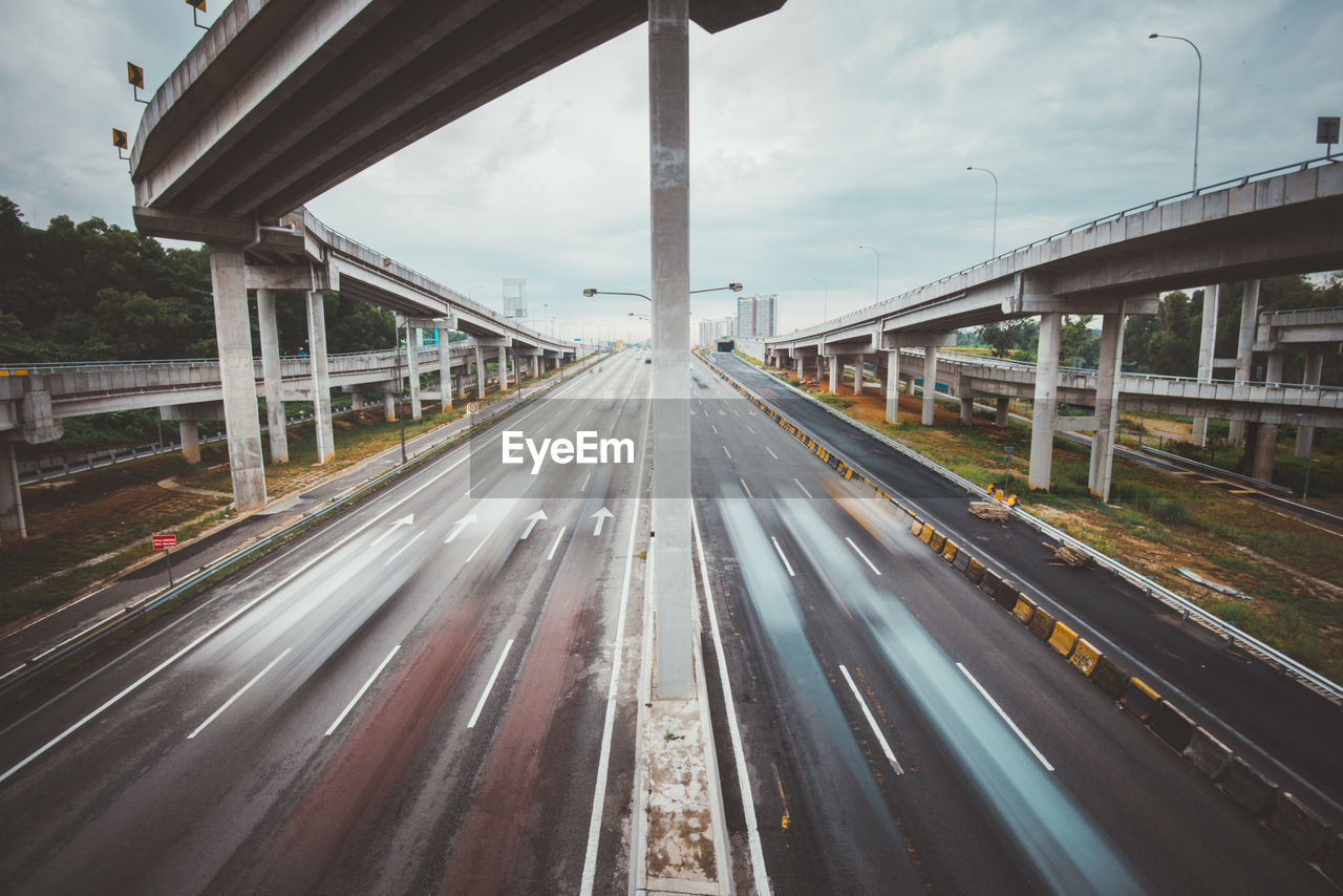 Blurred motion of vehicles on multiple lane highway below bridge