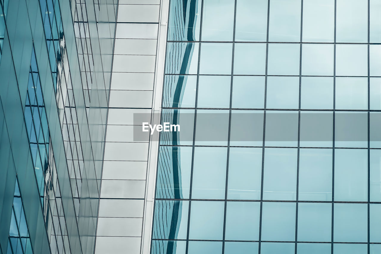 LOW ANGLE VIEW OF GLASS BUILDING WITH REFLECTION