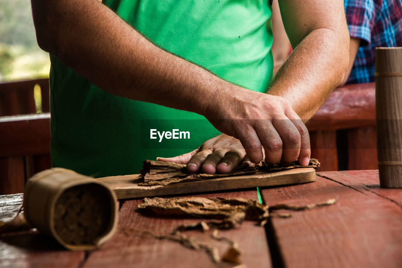 Close-up of man making cigar