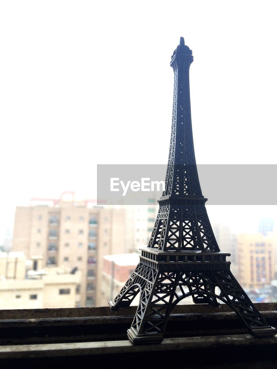 Close-up of replica eiffel tower at window against sky