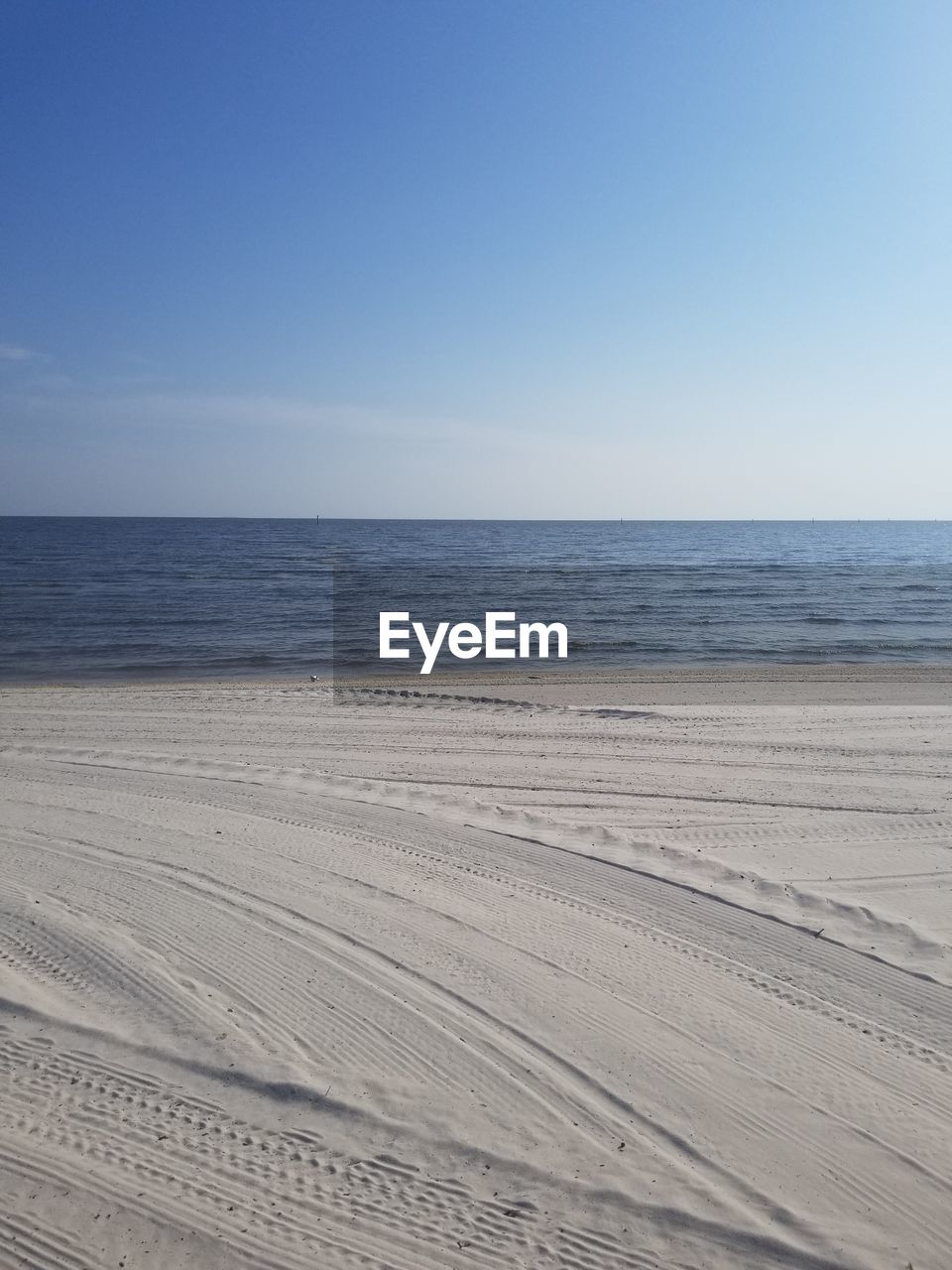 Scenic view of beach against clear blue sky