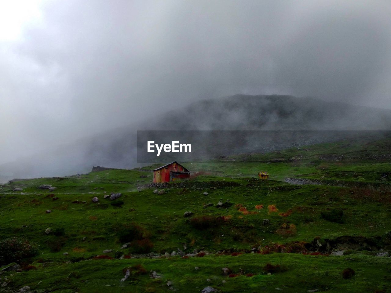 Mid distance of house on field against cloudy sky