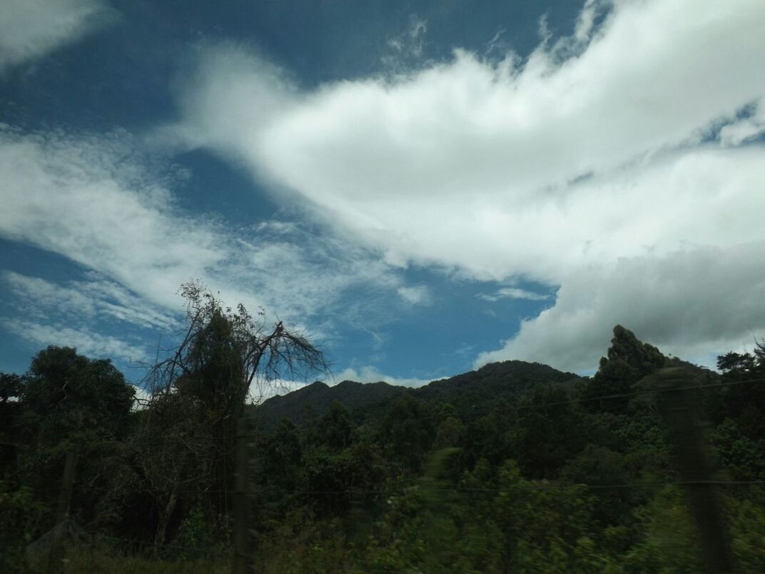 SCENIC VIEW OF MOUNTAINS AGAINST CLOUDY SKY