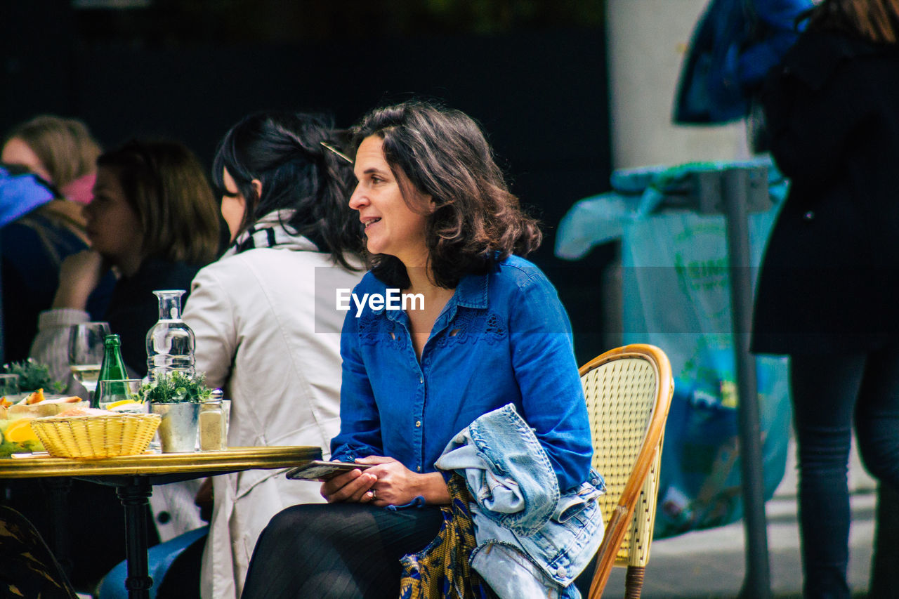 PEOPLE SITTING IN FRONT OF CHAIRS AT TABLE