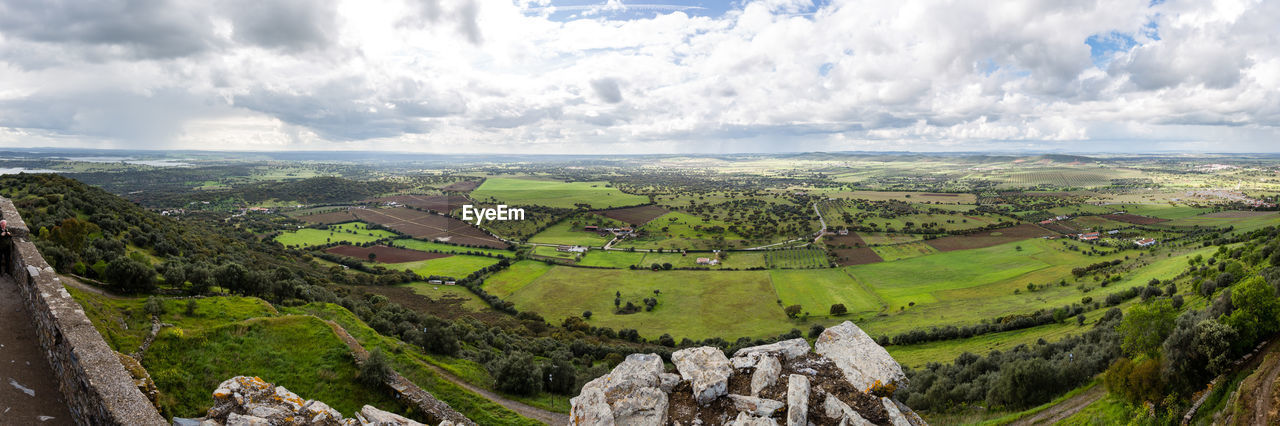 Panoramic view of agricultural field against sky