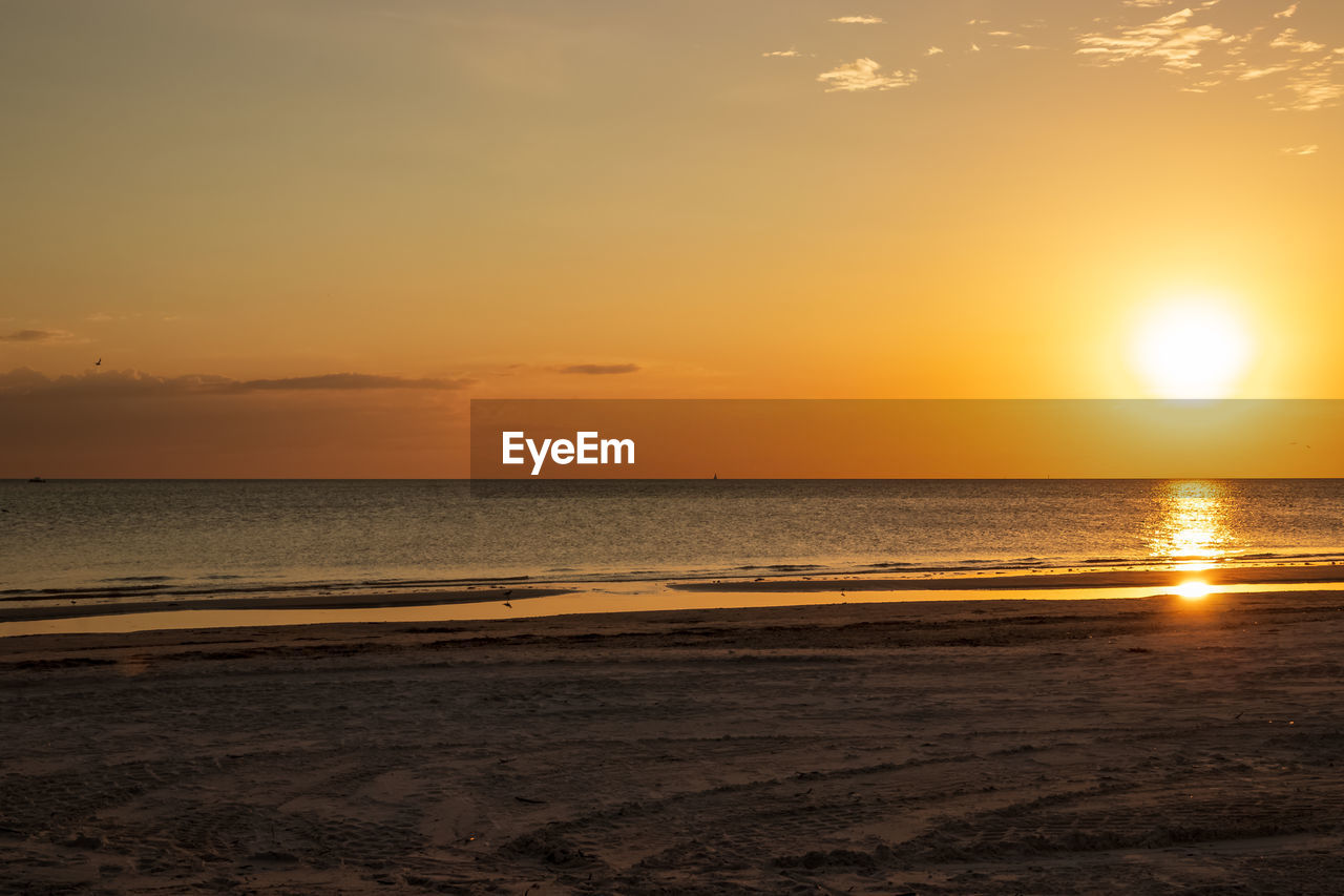 SCENIC VIEW OF BEACH AGAINST SKY DURING SUNSET